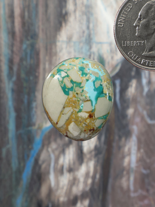 Oval turquoise cabochon gemstone with white and gold matrix details