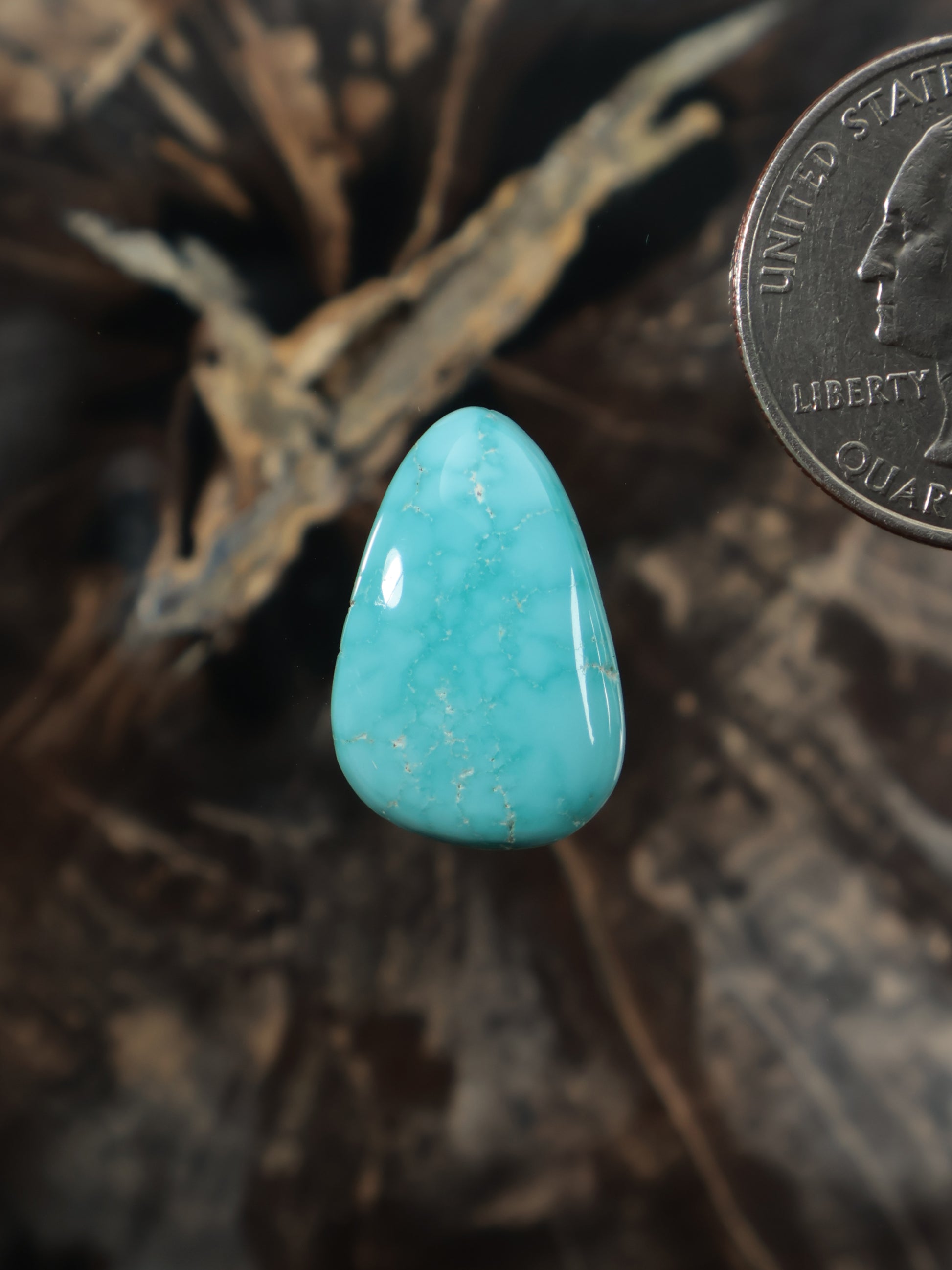 Turquoise cabochon gemstone, teardrop shape, bright aqua blue with natural veining