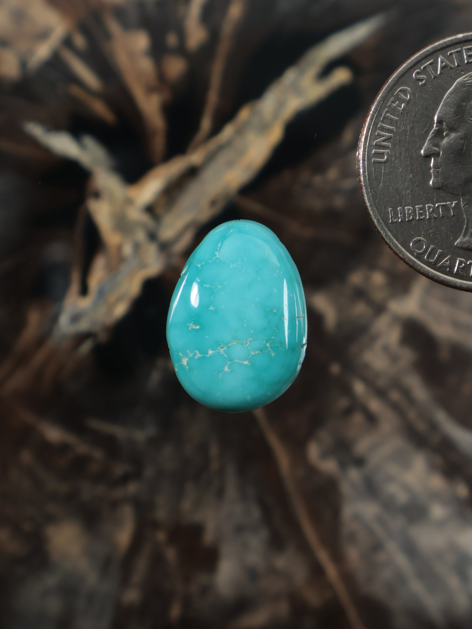 Turquoise oval cabochon gemstone with natural matrix veining, smooth polished surface