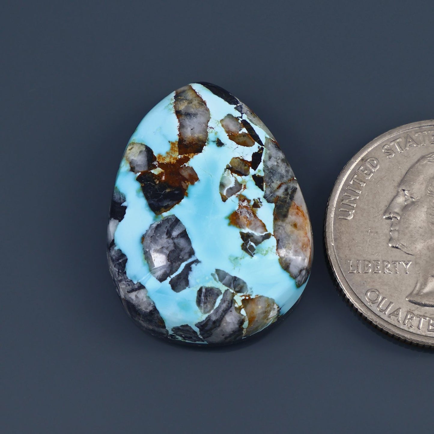 Turquoise cabochon gemstone, oval with mottled blue and brown stone matrix