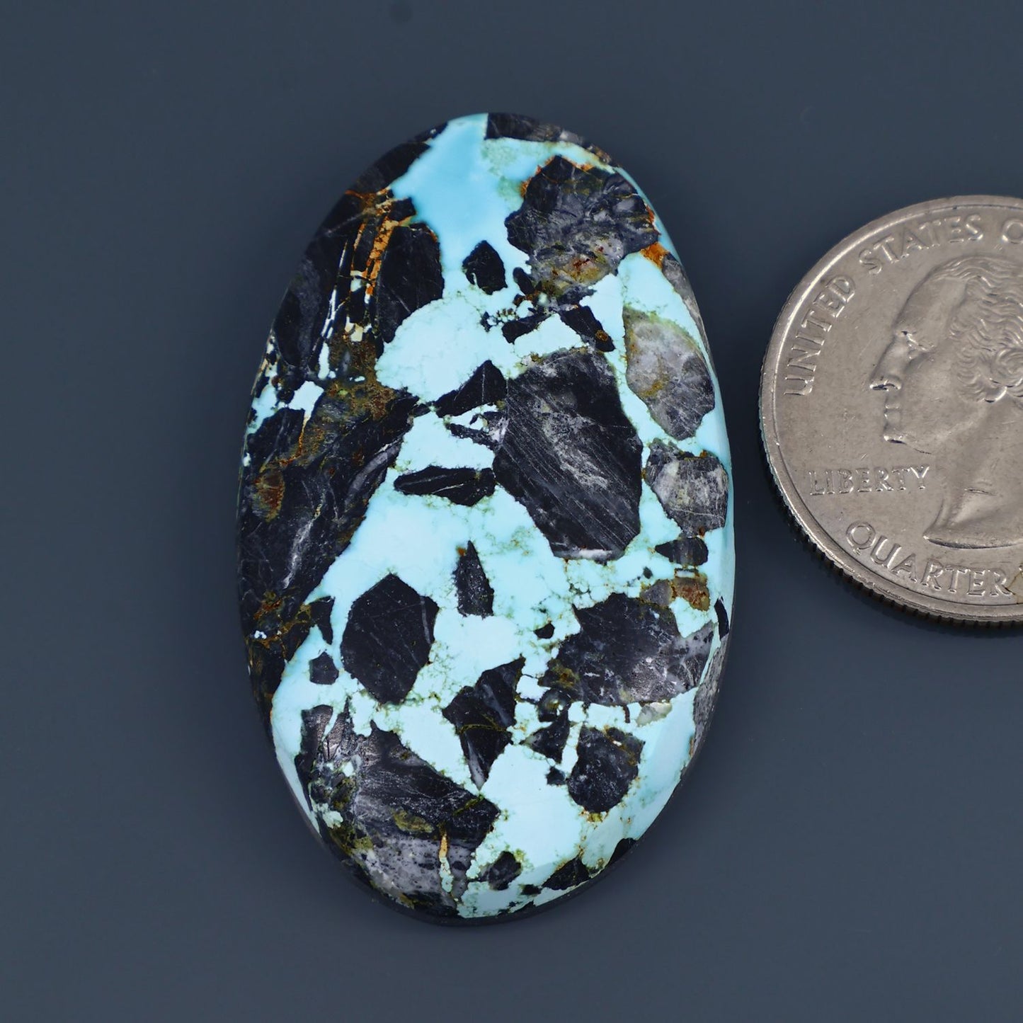 Turquoise and black oval cabochon gemstone