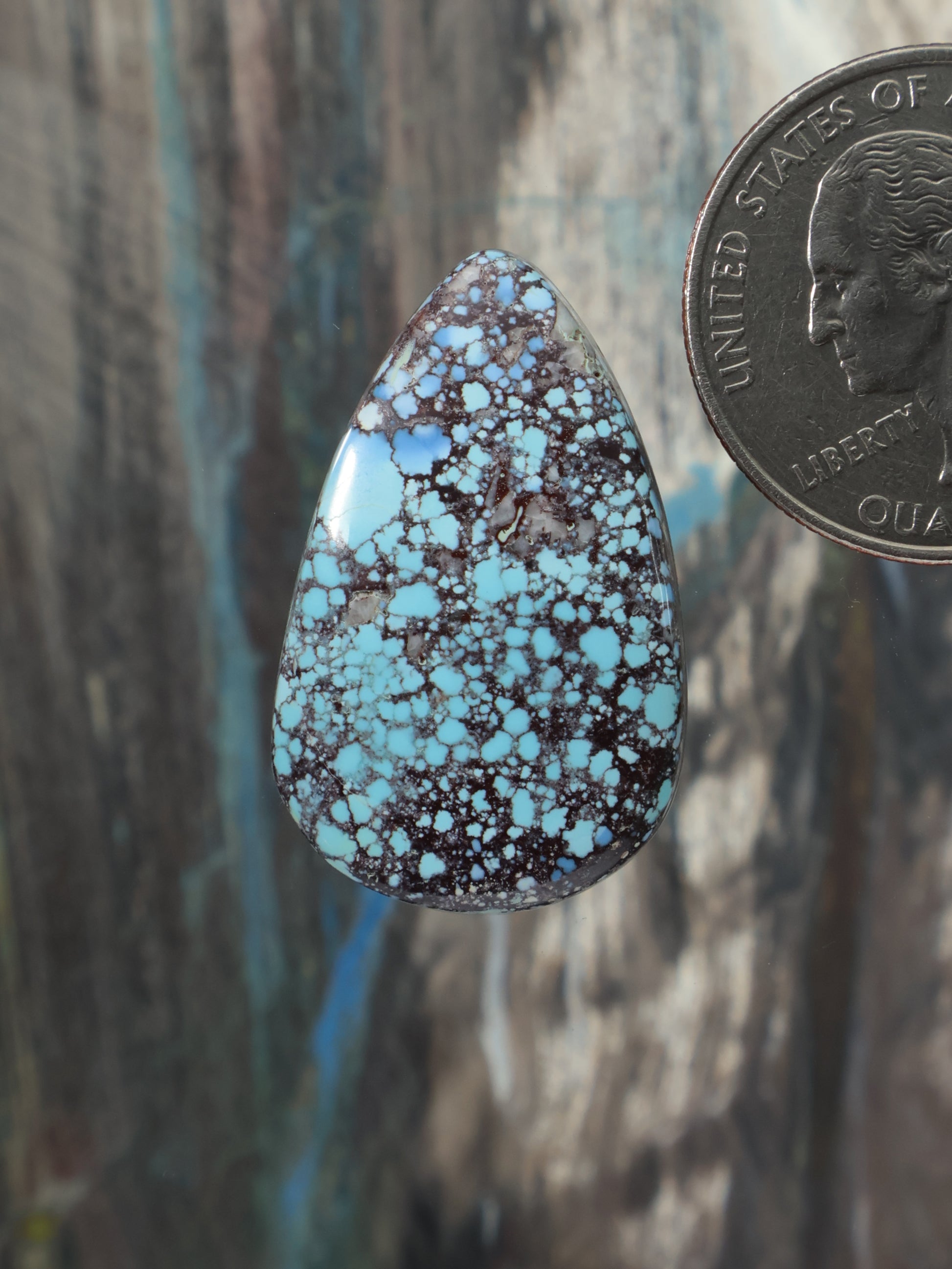 Turquoise teardrop cabochon with dark natural matrix and speckled pattern