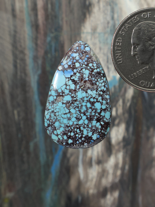 Turquoise teardrop cabochon with dark natural matrix and speckled pattern