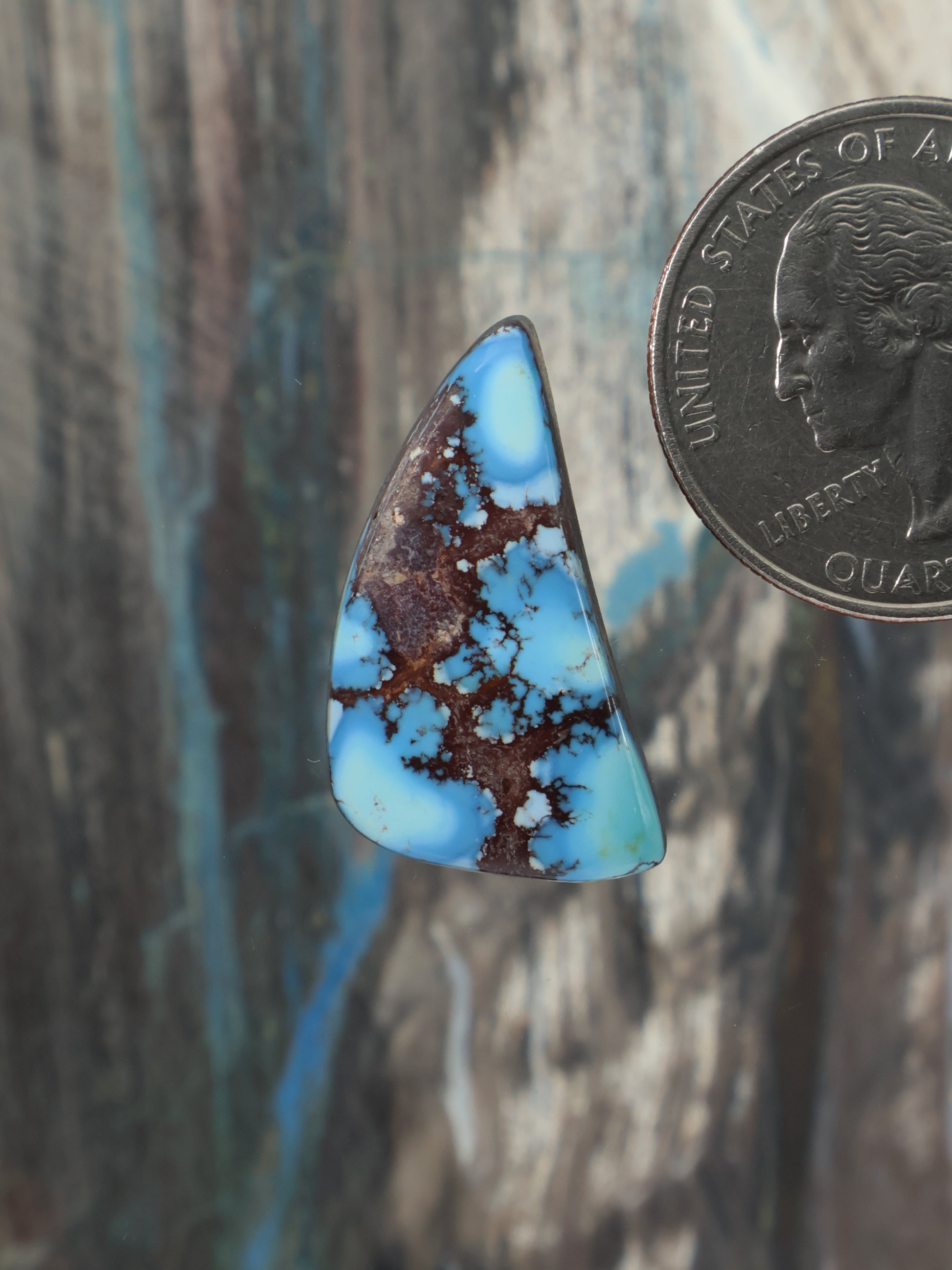 Turquoise and brown teardrop cabochon gemstone, blue center with dark matrix