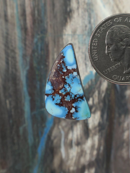Turquoise and brown teardrop cabochon gemstone, blue center with dark matrix