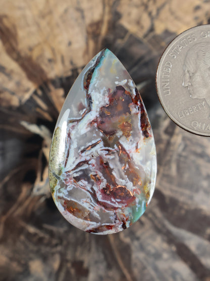 Tear-drop cabochon gemstone with light blue and green base, copper-red matrix veining