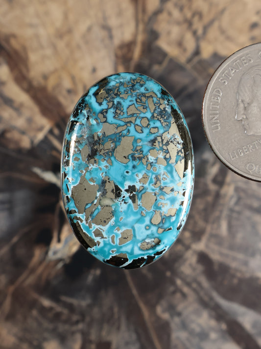 Blue turquoise oval cabochon gemstone with natural speckled pattern