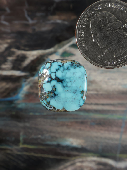 Oval turquoise cabochon gemstone with dark matrix veining