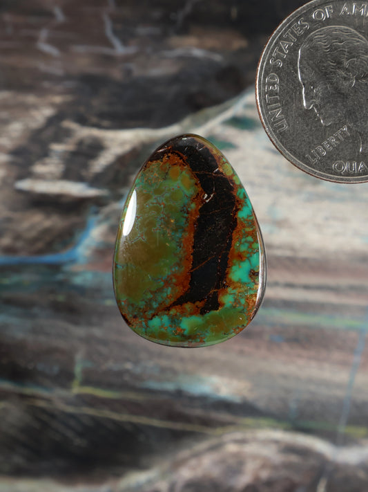 Turquoise cabochon gemstone, teardrop shape, green-blue with dark matrix, polished