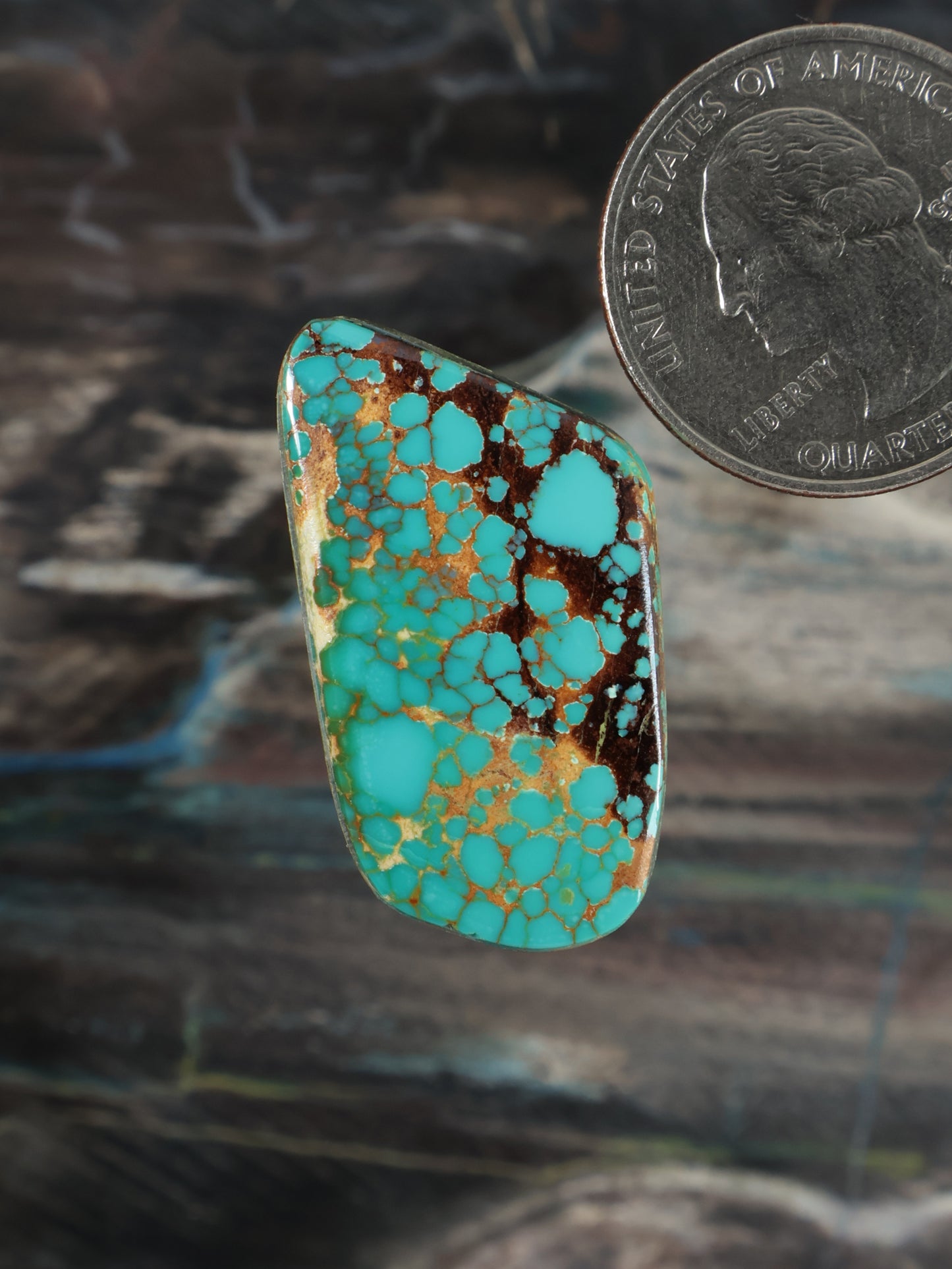 Turquoise cabochon gemstone with golden matrix, oval bezel setting
