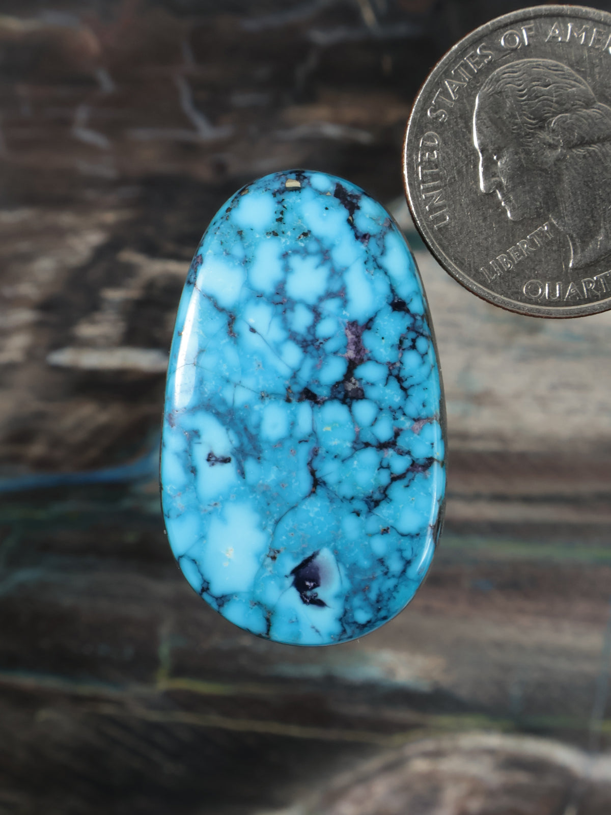 Blue turquoise cabochon gemstone with black veining, teardrop oval shape