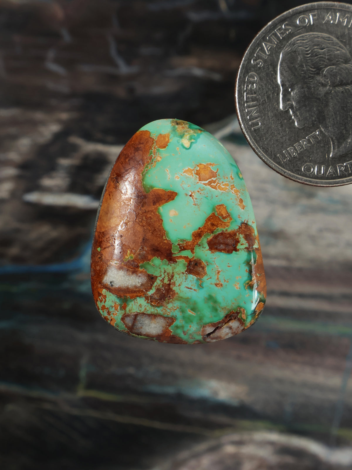 Turquoise cabochon with teal-green stone and brown matrix, oval polished gem.