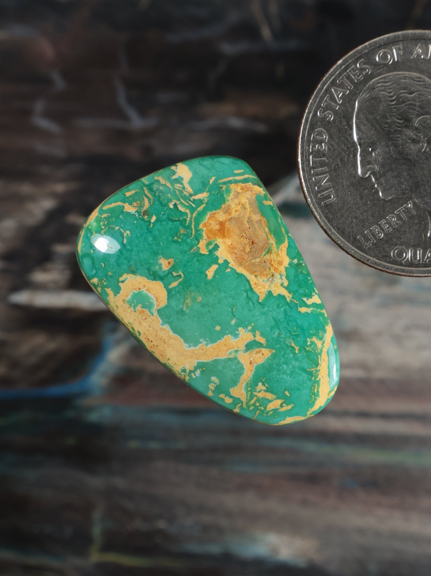 Oval turquoise cabochon gemstone at angle, gold-brown matrix pattern