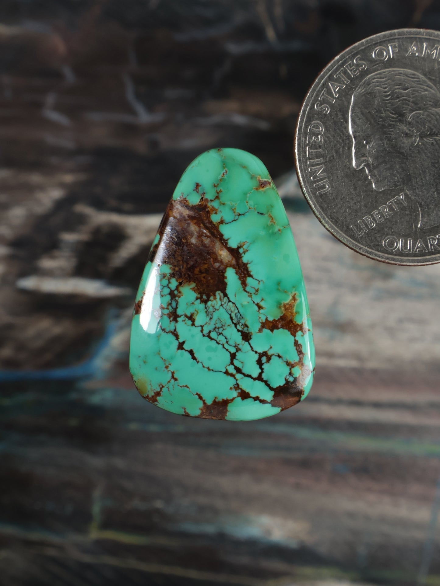 Turquoise cabochon gemstone with brown web-like matrix veining, teardrop shape
