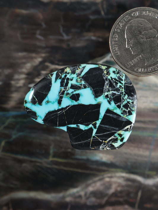 Turquoise and black cabochon gemstone, oval teardrop shape with natural veining