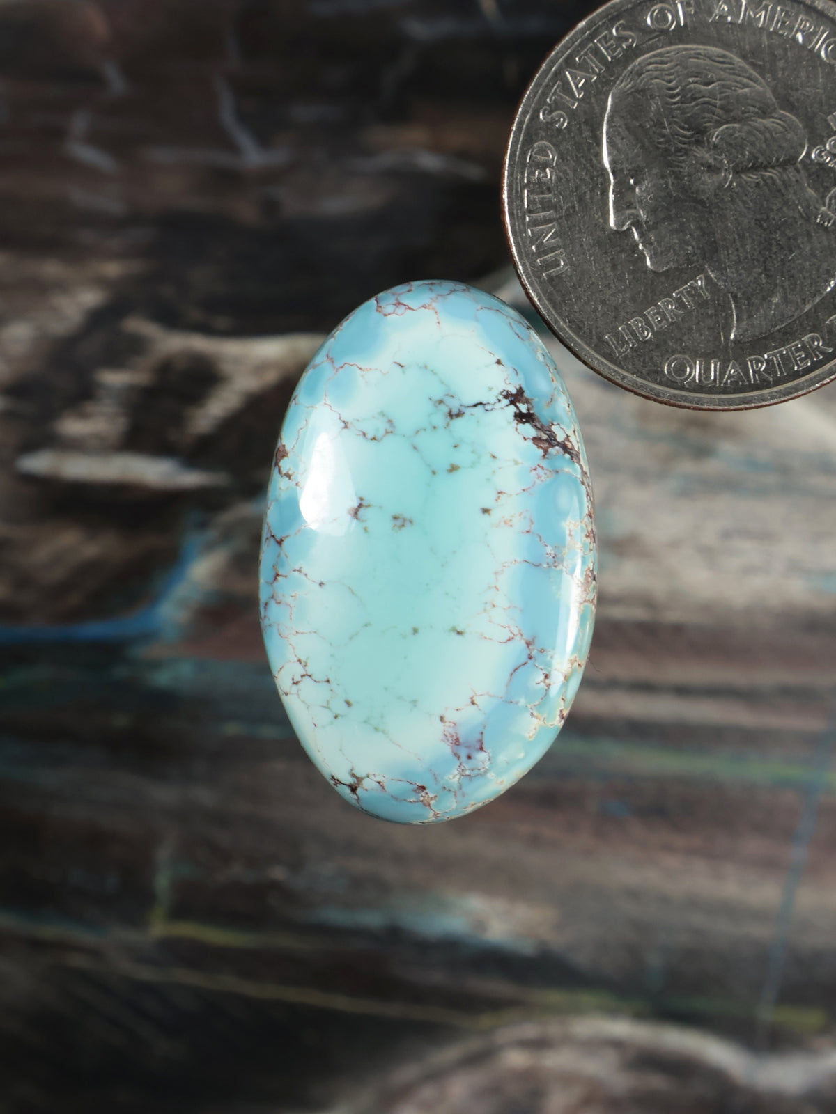 Oval light blue turquoise cabochon with natural brown veining, polished finish