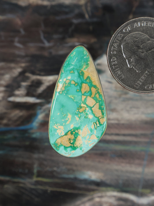 Teardrop turquoise cabochon gemstone with mottled matrix pattern, polished surface