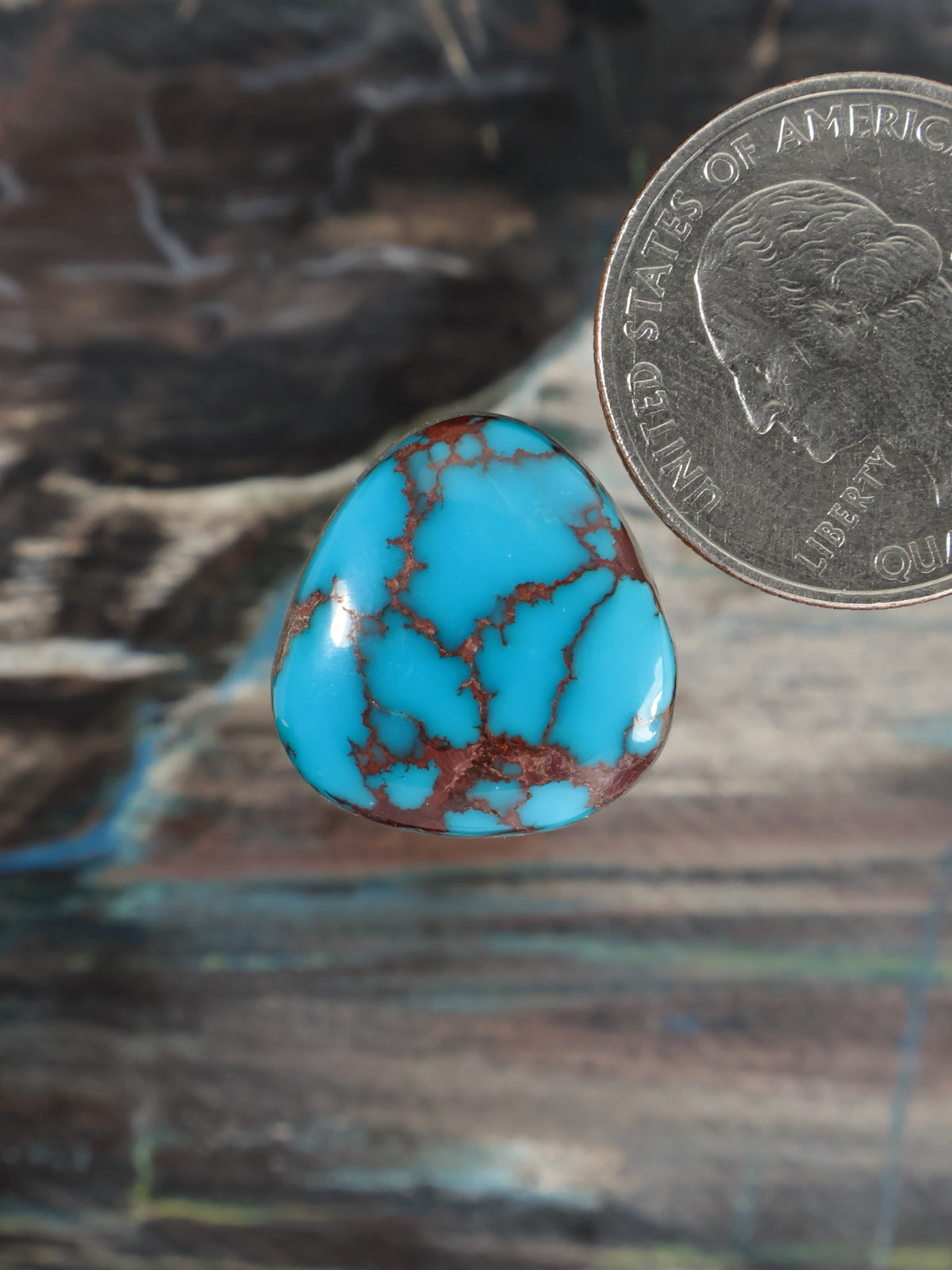 Turquoise teardrop cabochon gemstone with webbed red-brown veins