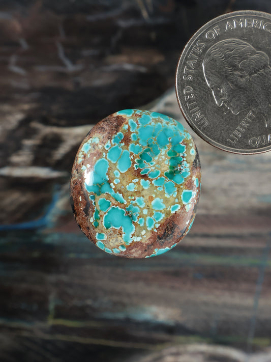 Turquoise and brown oval cabochon stone with natural matrix pattern
