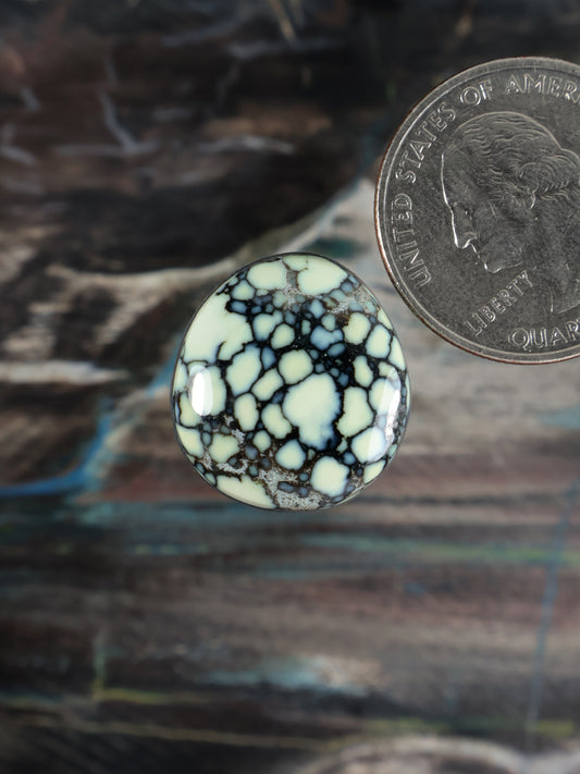 Round variscite cabochon with pale blue base and white veining, no setting