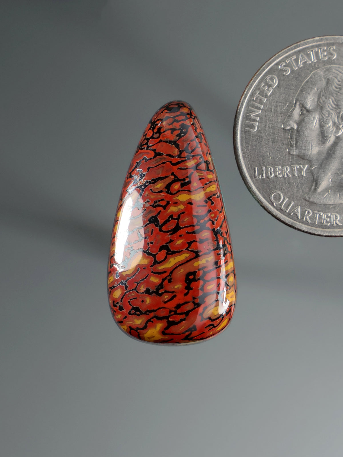Dinosaur gembone cabochon, teardrop red-orange with dark black mottled pattern