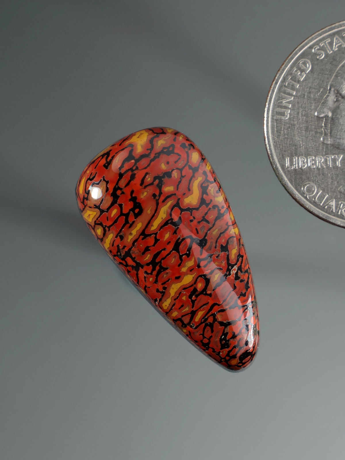 Dinosaur gembone cabochon, angled teardrop with red-orange and black marbled pattern