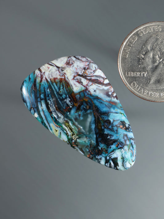 Blue marbled cabochon gemstone, rounded oval with white-red web and streaks