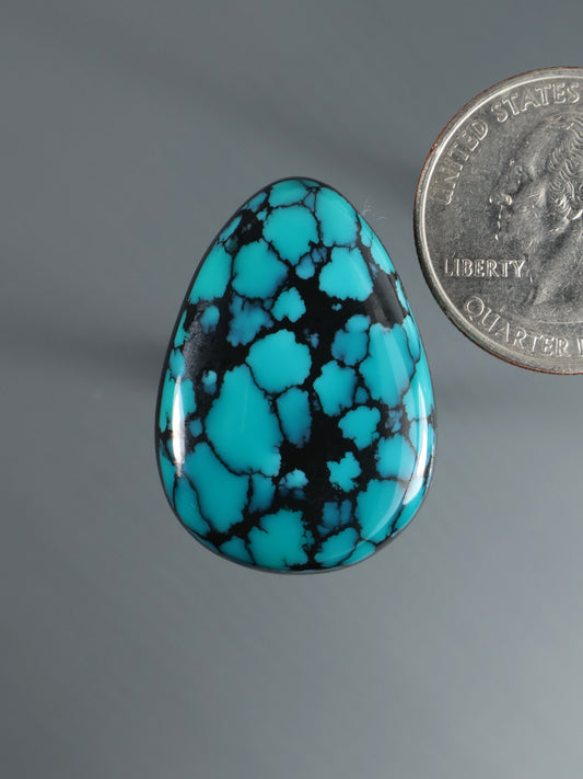 Turquoise blue and black teardrop cabochon gemstone