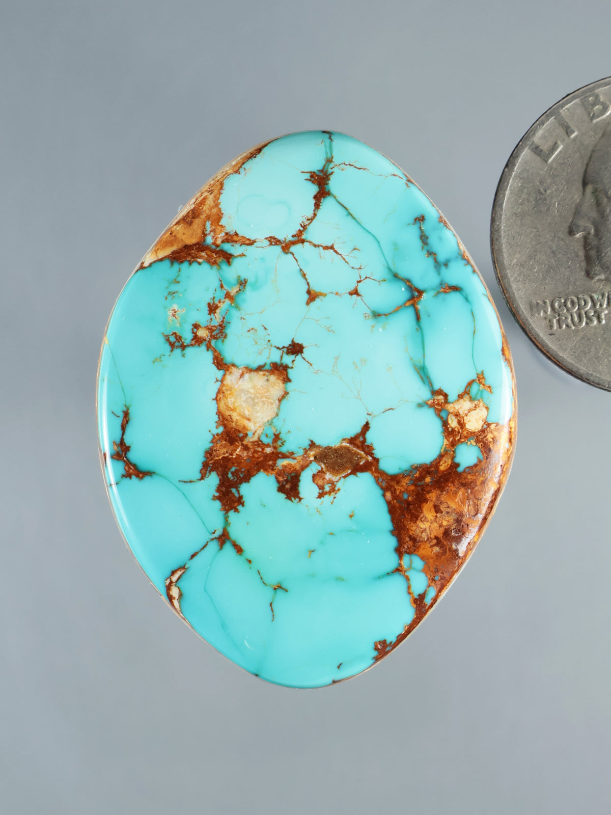 Large oval turquoise cabochon gemstone with brown matrix veining