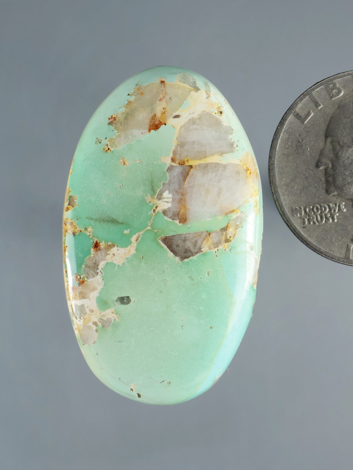 Oval turquoise cabochon with light matrix veining and mottled pattern