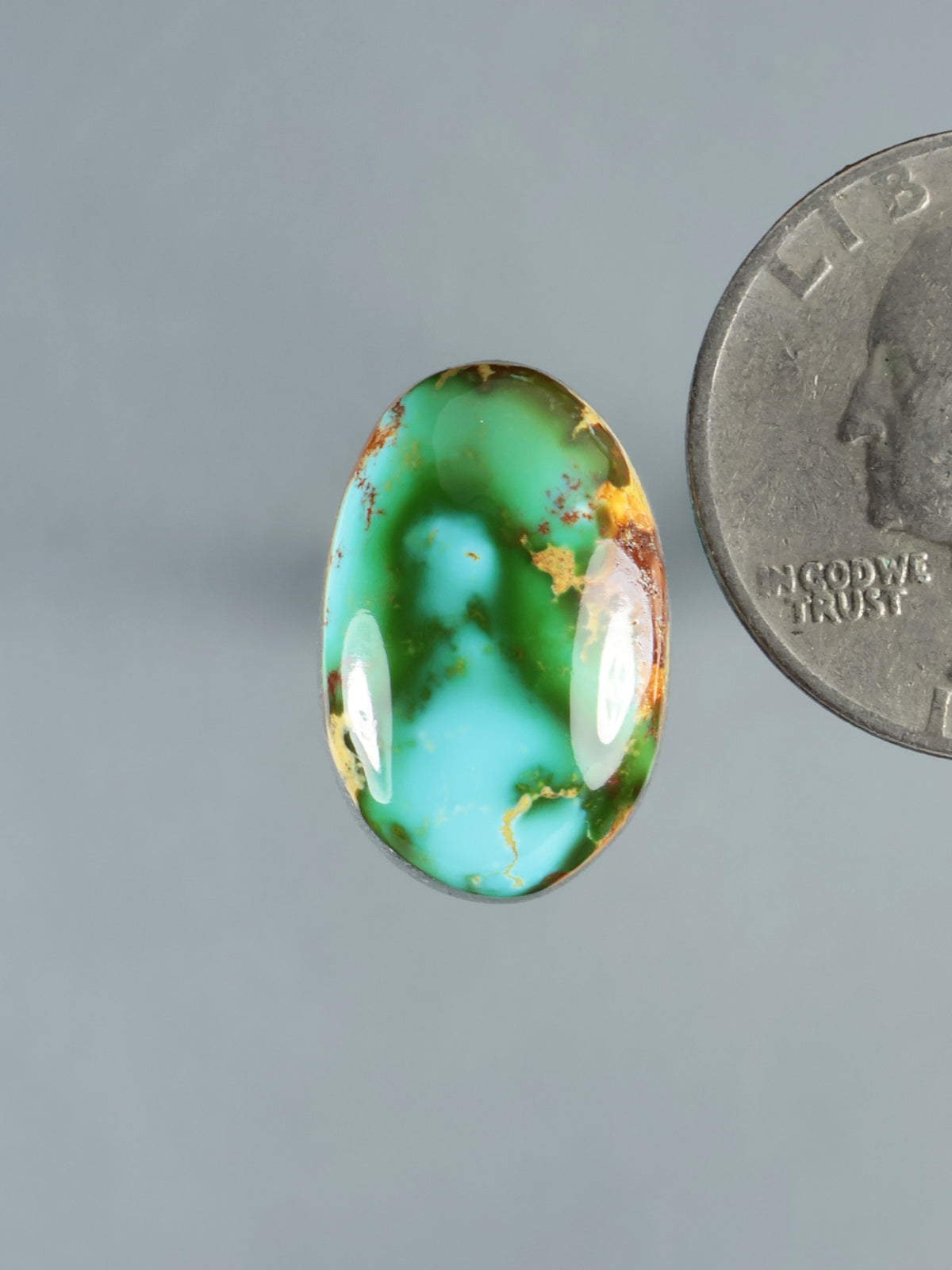 Oval turquoise cabochon, polished green stone with brown matrix veining and cab sheen