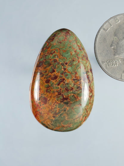 Dinosaur gembone cabochon (B892), oval green-orange mottled stone with glossy polish