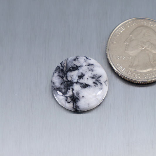 Round white feather cabochon with black marble-like veining, smooth bezel