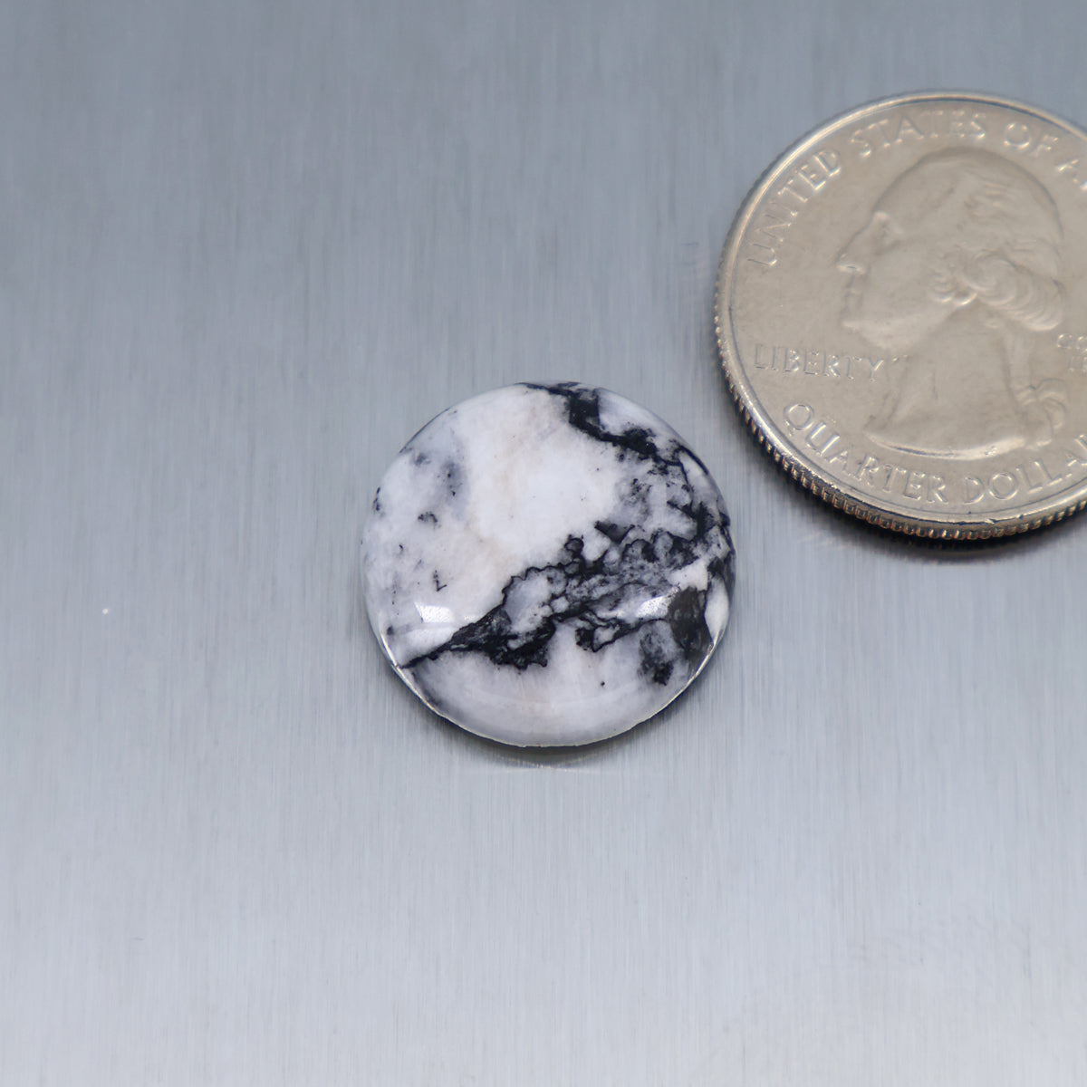 White feather cabochon stone, round with dark feathered vein pattern